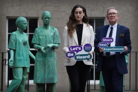 Dr Alexandra Anderson, head of the Scottish Covid Inquiry's Let's Be Heard project, and Lord Brailsford, chair of the inquiry, next to a memorial to NHS staff tackling Covid-19 in Edinburgh