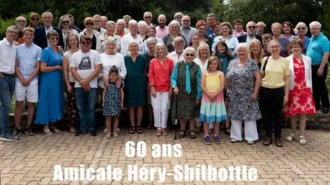 Amicale Hery Shilbottle Association A big group of people with a caption saying 60 years of friendship 