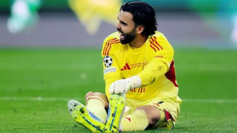 David Raya of Arsenal goes down holding his foot during the 2026 UEFA Champions League final against Paris St-Germain