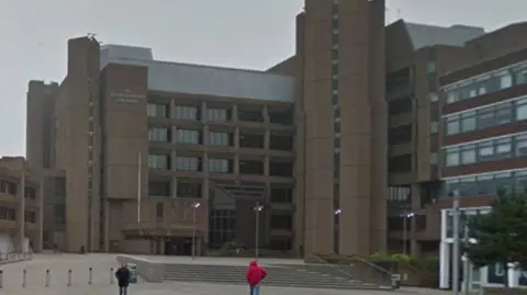 Two people walk in from of the law courts in Liverpool