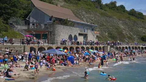 PA Media People in the hot weather on Sunny Sands beach in Folkestone
