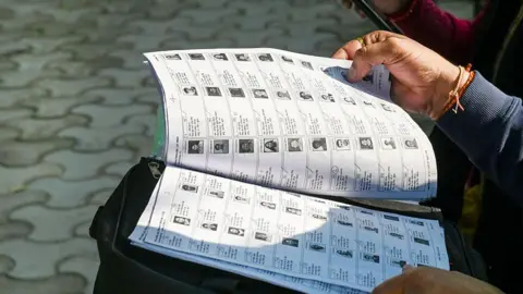 Hindustan Times via Getty Images Official checking voters details in list as part of the statewide Special Intensive Revision (SIR) of the electoral rolls 