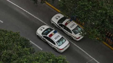 Getty Images File photo of two police cars in Shanghai