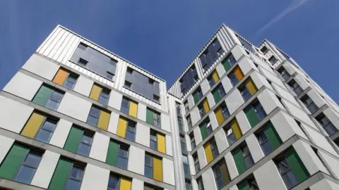 A white building with yellow and green windows