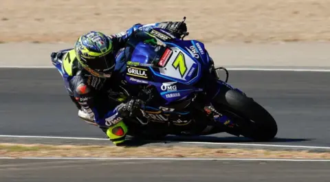 Ian Hopgood Ryan Vickers on a powerful motorbike in racing gear leans into a corner on a racing circuit