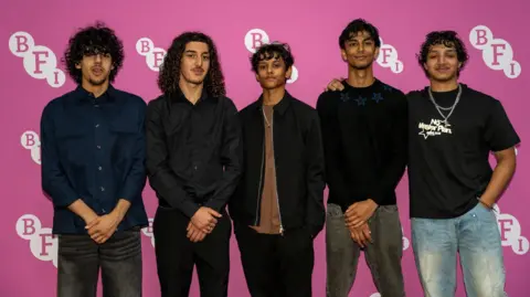 BFI Five young cast members from Ish pose in front of a pink BFI backdrop.