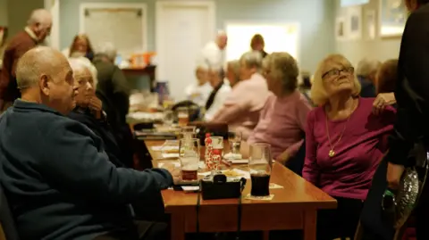 Provided Another shot from the club, showing more people sat around tables - but no straws this time.