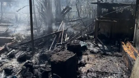Staffordshire Fire and Rescue Service Fire damage, including to a structure on the top right, is prominent on the image. Smoke is visible in the top half of the photo on the left.