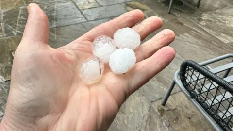 BBC Weather Watchers / Anna P Hand holding four hailstones the size of ice cubes