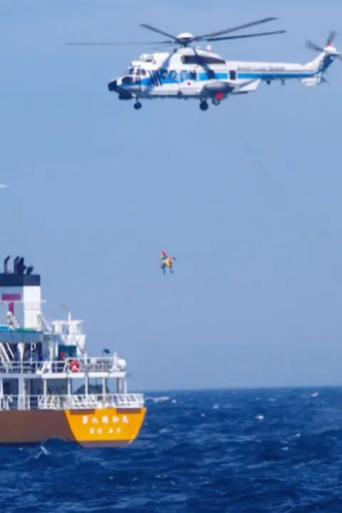 Japan Coast Guard/Kyodo Coast Guard helicopters airlift the woman to take her to hospital