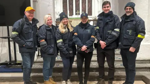 Surrey PCC Surrey Police and Crime Commissioner Lisa Townsend stands in Guildford town centre flanked by five members of the Street Angels team, all wearing branded jackets.