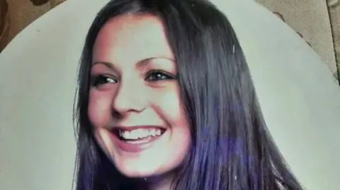 Family Handout Headshot photo of a woman with long brown hair and brown eyes.