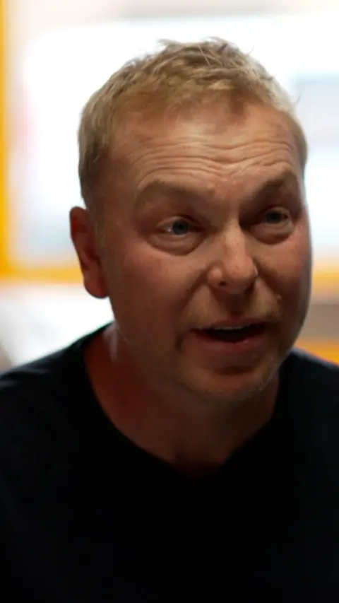 Man with blonde hair slightly raising his eyebrows