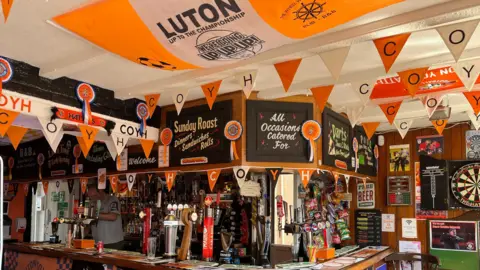BBC/Nicola Haseler Bar area of a pub festooned with Luton Town bunting
