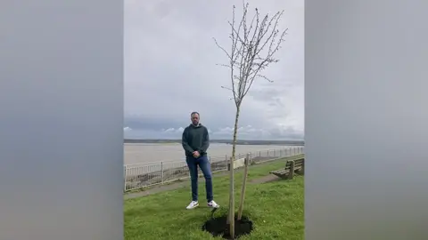 BBC Daniel Snow next to the tree