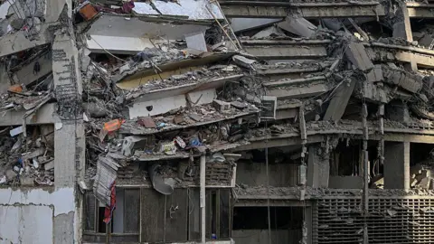 Federico PARRA/AFP via Getty Images A general view shows apartments in a damaged building following an earthquake in Catia La Mar, La Guaira state, some 30km north-west of Caracas, on June 25, 2026.