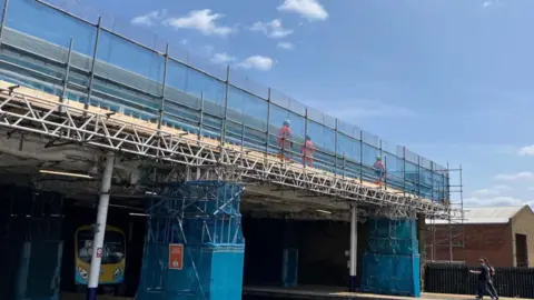 Network Rail Scarborough Railway Station covered in scaffolding and blue safety mesh
