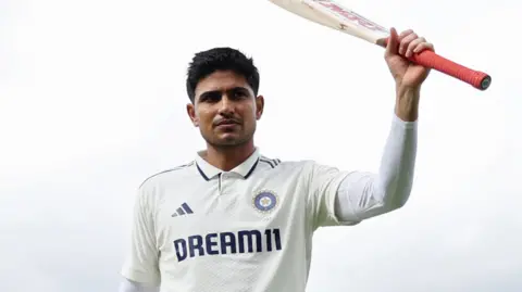 Shubman Gill raises his bat after hitting a century