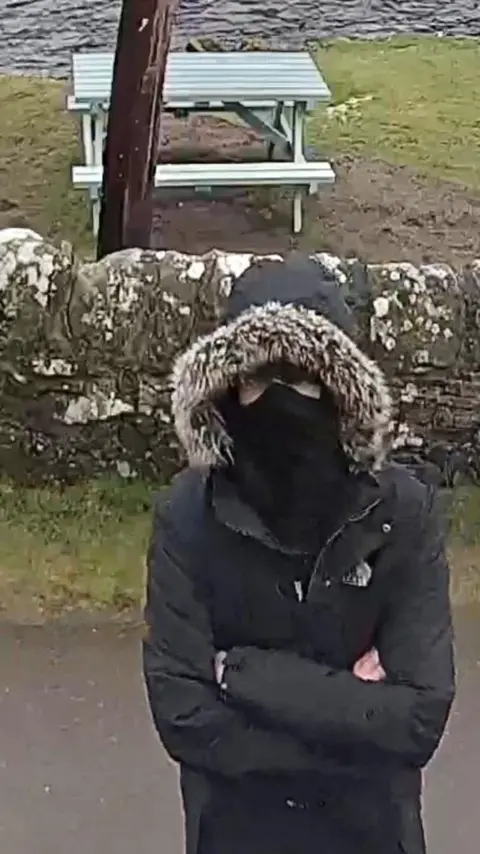 Loganlea Fishery A vandal wearing black clothes with a mask and a furry hood.