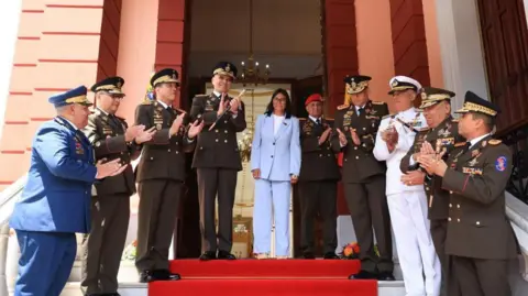 Handout via REUTERS Venezuela's acting President Delcy Rodriguez poses for a photo with members of the Venezuelan military command and General Gustavo Gonzalez Lopez, who took over as defence minister from General Vladimir Padrino, in Caracas, Venezuela, March 19, 2026. 
