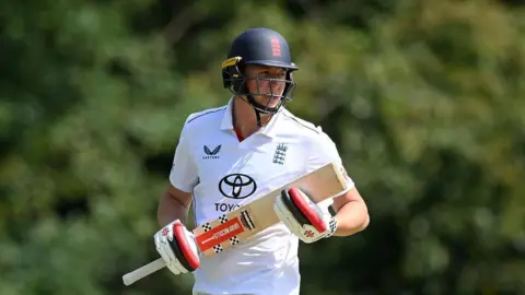 Ben McKinney batting for England Lions, with England helmet and England kit on