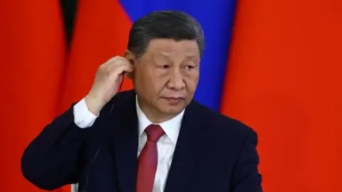 Reuters Chinese President Xi Jinping adjusts an earphone during a signing ceremony following talks with his Russian counterpart Vladimir Putin 