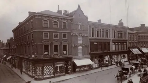 University of Glasgow, House of Fraser Archive This is what the House of Fraser site looked like c.1900, when the shop was called Mawer and Collingham. In the centre of the picture a row of victorian shops can be seen. On the street are pedestrians in period dress, and a row of horse drawn carriages.