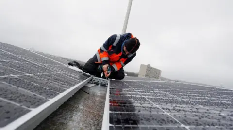 Reuters Solar panels being fitted on roof
