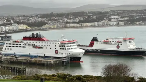 BBC The Manxman and Ben-my-Chree ferries moored in Douglas Harbour. The are painted in the Isle of Man Steam Packet Company's colours of white, red and black. Douglas Bay and Promenade can be seen the background.
