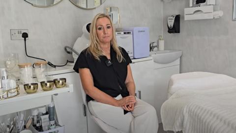 Jodi Holland sitting in her beauty therapy treatment centre
