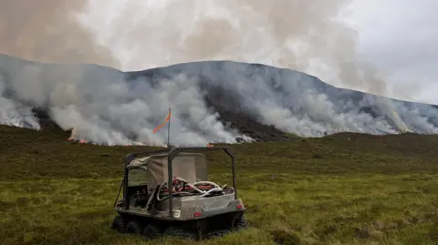 RSPB Scotland A small all-terrain vehicle with fires burning along a hillside.