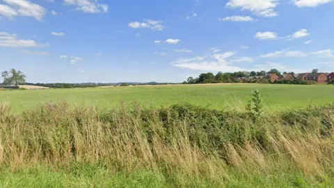 Google A street view image of fields near Scraptoft. There are homes to the right of the field. 