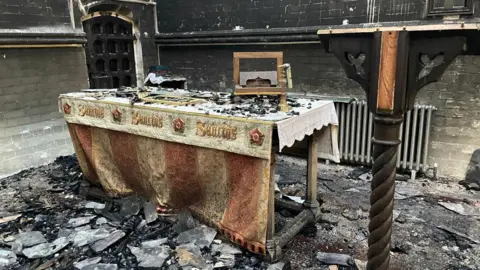 Elizabeth Amias the altar is burnt and everything around it is black but the altar frontal still has some colour and looks intact 