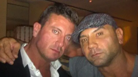 Jason Burrill A man, Jason Burrill, left, stood next to another man, Dave Bautista, right, who has his arm over his shoulder.