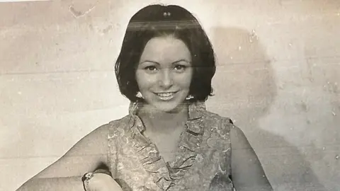A black and white photo of a woman with an up-do 