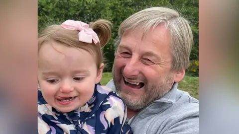 Family holding Kevin with his granddaughter