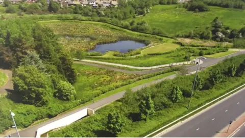 Green fields and a pond next to the A50 road in Derbyshire. 