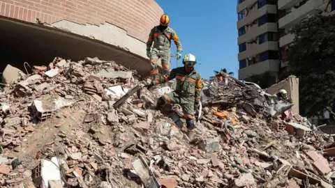 Members of rescue teams from Mexico are conducting search operations in a building damaged by an earthquake in La Guaira, Venezuela, 29 June 2026.