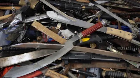 PA Media A collection of knives surrendered to police during an amnesty in Glasgow in 2008.