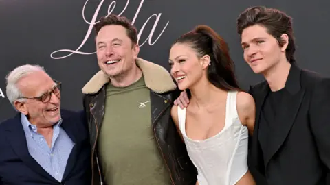 Getty Images Nelson Peltz, Elon Musk, Nicola Peltz Beckham e irmão Will Peltz