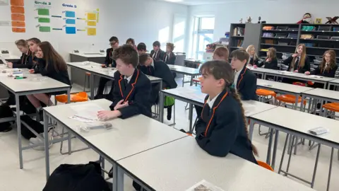 A classroom of year 7 pupils looking at their teacher