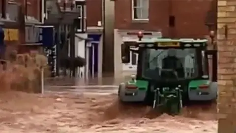 Tractor driving through flood water in Tenbury Wells