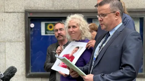 JANINE MACHIN/BBC Yvonne Valentine holding a picture of her son
