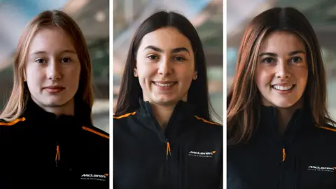 McLaren Racing Three females in a composite image. They are separated by a white block. Left to Right - Ella Häkkinen, Ella Lloyd and Ella Stevens. They are all wearing a black McLaren zip top with an orange line running down the shoulders.