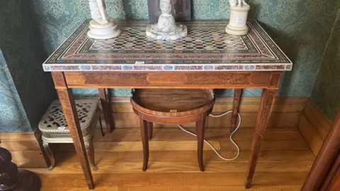 Victor Mee Auctions A multi-coloured marble-topped table which originated from Tandragee Castle.  The rare early 19th Century piece is raised on a burr walnut base and square tapered legs.