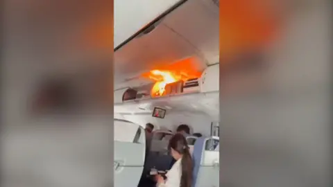 A fire caused by a lithium battery in an overhead locker inside an aeroplane cabin.