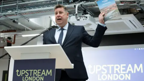 Upstream London Council leader Steve Cowan in a navy suit, blue shirt and navy tie.