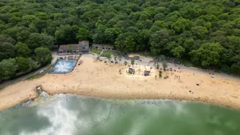 Getty Images A beach can be seen beside a green-blue lake