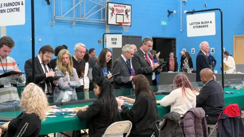 Simon Dedman/BBC Members from different parties observe vote counting.
