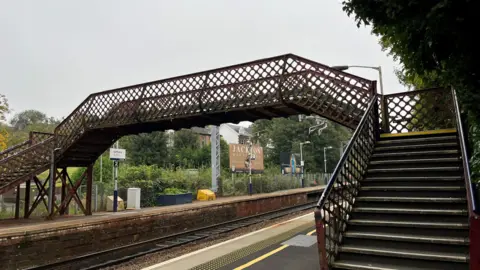 Photo of red iron footbridge over the railway